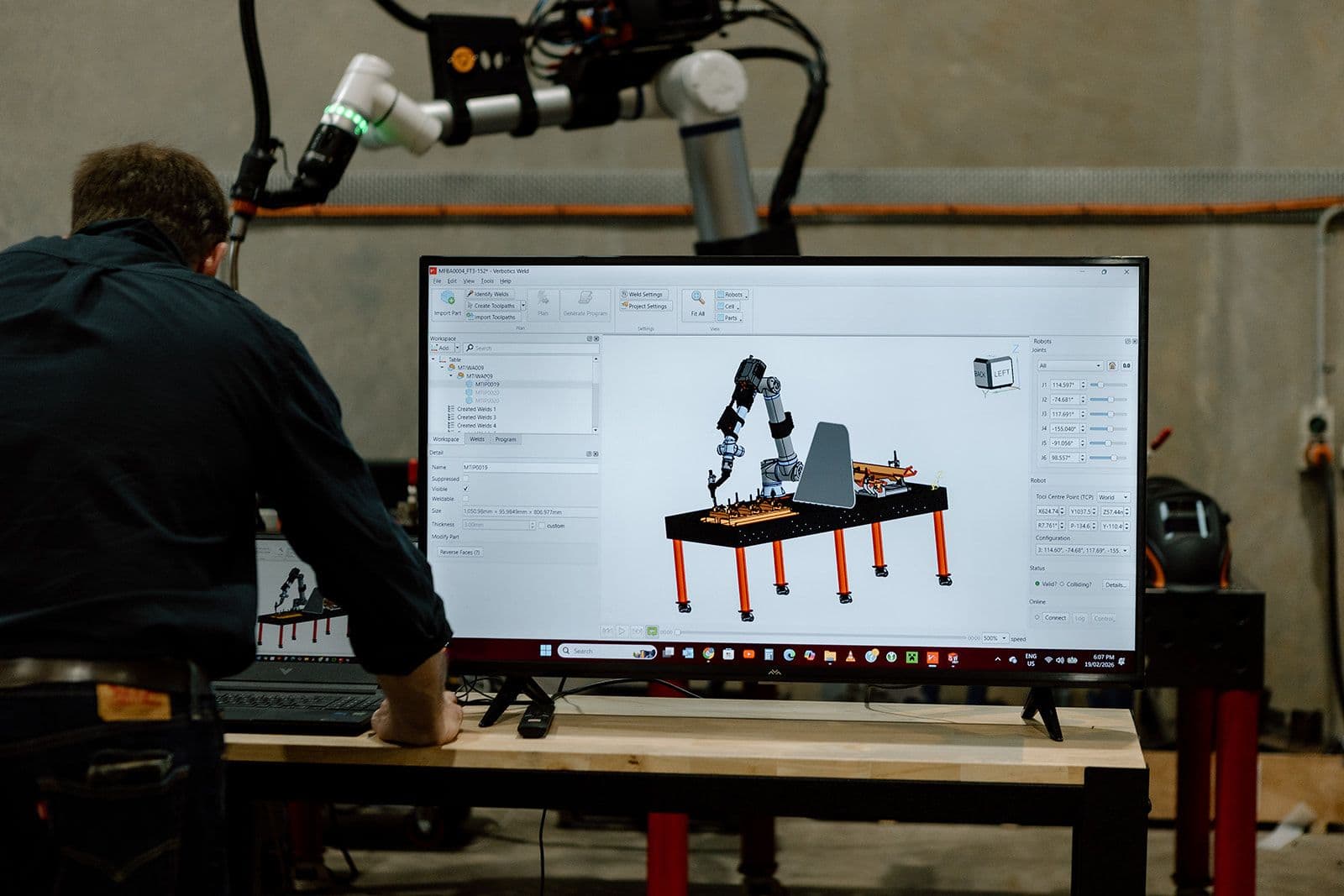 Operator at Verbotics Weld monitor with cobot arm in background